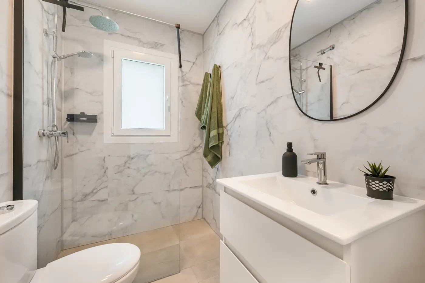 Bathroom 2 with a round mirror and marble finish